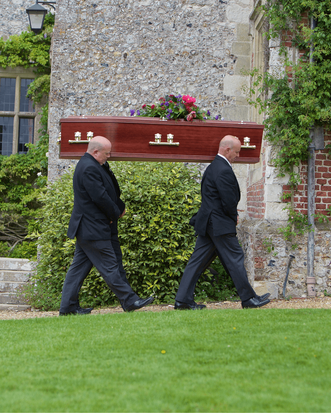 Four pallbearers carrying a coffin