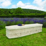 The Cane Coffin with small purple flower bouquet on top